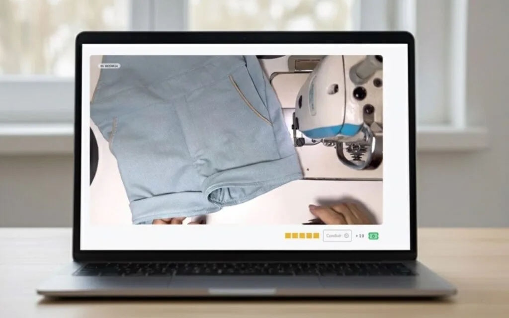 Notebook aberto mostrando aula de costura da Jardineira Premium sendo assistida